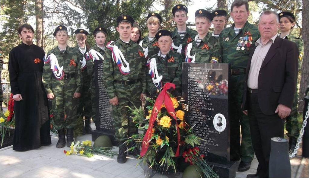 члены отряда Память с сыном красноармейца Шерцова на новом мемориале, где перезахоронены останки умерших в 138 госпитале